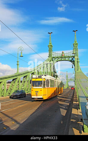 Orange Straßenbahn auf der Liberty-Brücke über die Donau in Budapest, Ungarn Stockfoto