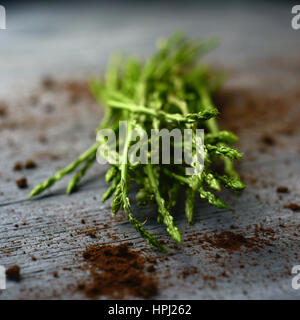 Nahaufnahme von einem Haufen wilder Spargel auf einer rustikalen Holzoberfläche Stockfoto