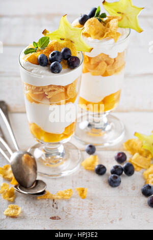 Joghurt-Müsli-Parfait mit Mango und tropischen Früchten, geschichtete Dessert oder Frühstück Stockfoto