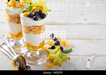 Joghurt-Müsli-Parfait mit Mango und tropischen Früchten, geschichtete Dessert oder Frühstück Stockfoto