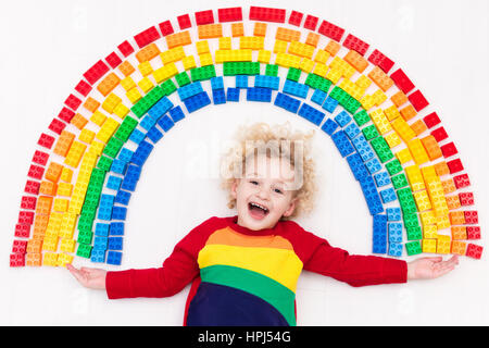 Lustige kleine Junge spielt mit regenbogenfarbenen Kunststoffblöcke. Kinder spielen, erstellen und Farben zu lernen. Pädagogisches Spielzeug für kreative Kinder. Vorschüler Stockfoto