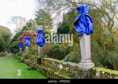 Stein-Statuen in einem formalen Garten bedeckt blau planen zum Schutz gegen Winterfrost. Stockfoto