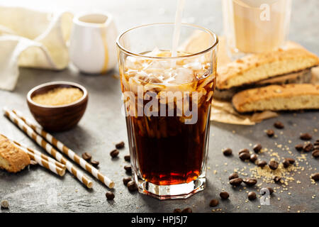 Eiskaffee in ein hohes Glas mit Eis gegossen Stockfoto