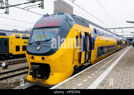 Nederlandse Spoorwegen gelbe und blaue Zug auf eine Plattform in den Niederlanden Stockfoto