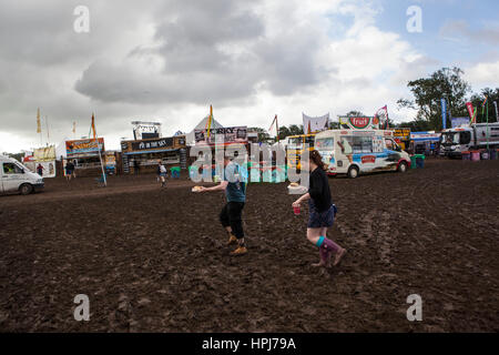 Ricky Pateman und Fe Evans aus Stevenage, die ihren Weg durch den Schlamm mit ihrem Frühstück am Morgen des 3. Tag von Glastonbury Musik Festi Stockfoto