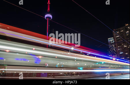 CN Tower in Toronto bei Nacht mit einem Straße Auto vorbei, wodurch Lichtspuren in dunklen Himmel (passenden Farben mit CN Tower) Stockfoto