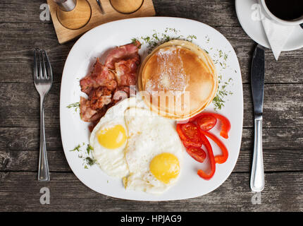 Gesundes Frühstück mit weggeschworen, Speck, Spiegelei und Gemüse. Ansicht von oben Stockfoto