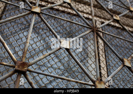 Alte rostige Metallgitter auf einem städtischen Fensterhintergrund Stockfoto