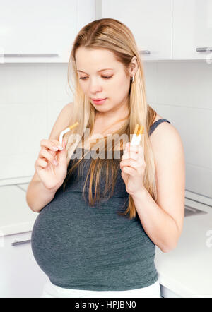 Schwangere Frau versucht, Qiut Rauchen und Zigaretten zu brechen Stockfoto