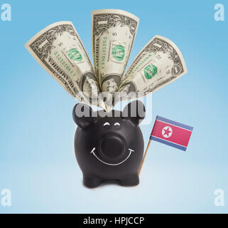 Ein-Dollar-Banknote in ein lächelndes Sparschwein von Nordkorea. (Serie) Stockfoto