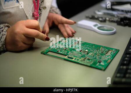 Nahaufnahme einer Arbeitnehmerin Elektronik Circuit Board testen Stockfoto