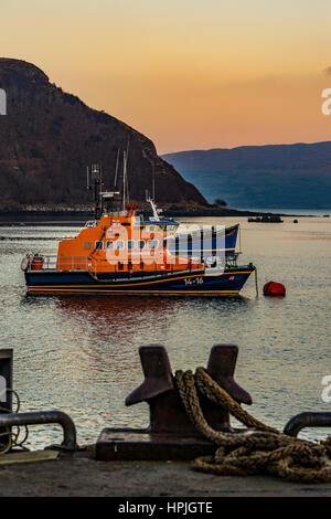 Portree Rettungsboot, RNLB Stanley Watson Barker, verankert im Hafen von Portree, Isle of Scotland, vom Kai, Sound of Raasay im Hintergrund orange Himmel Stockfoto