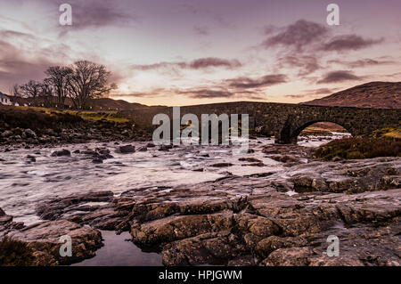 Die alte Brücke in Sligachan, Isle Of Skye, Schottland, mit der Sonne im Winter. Stockfoto