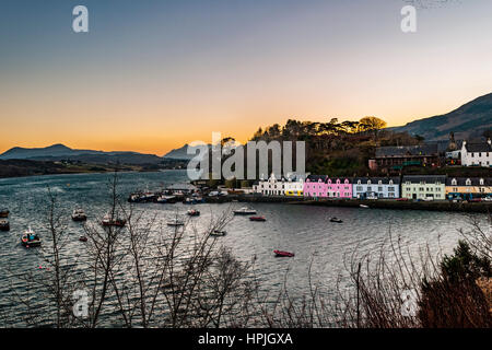 Bunte Häuserzeile entlang des Kais am Hafen von Portree, von oben Hafen mit roten und schwarzen Cuillin hinter und gelb/Orange Leuchten Stockfoto