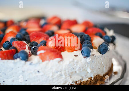 Eine leckere Erdbeeren und Heidelbeeren Käsekuchen mit Schokolade Brocken. Stockfoto