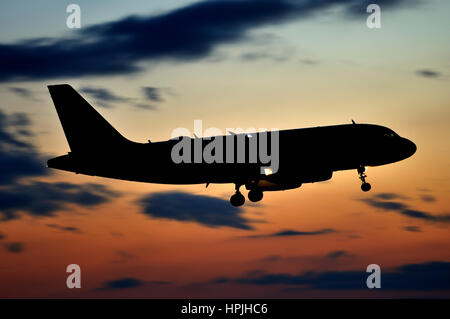 Silhouette des Airbus A319 Passagierjet Flugzeug Landung in der Abenddämmerung, Seitenansicht nach rechts Stockfoto