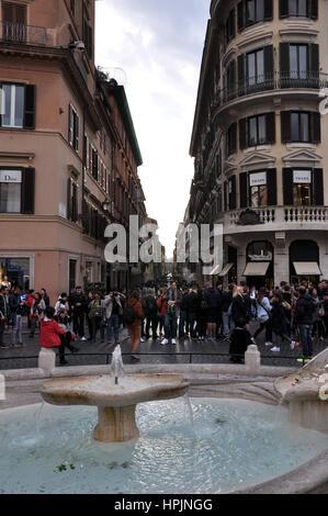 Rom, Italien - 14. März 2016: Touristen, die die Piazza di Spagna (spanischer Platz), die spanische Treppe und die Fontana della Barcaccia in Rom Stockfoto