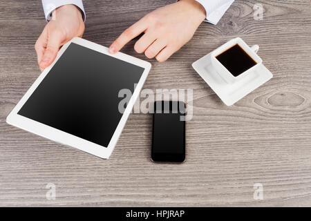 Office Desktop-sind-Bruch mit der Tablette in Händen und Tasse Kaffee Stockfoto