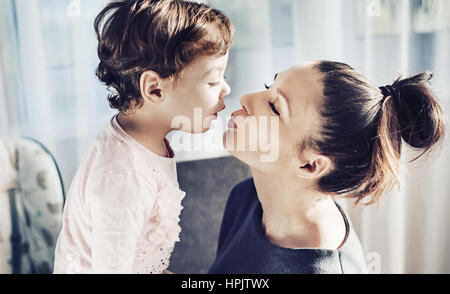 Porträt einer Mutter küssen ihre geliebte Tochter Stockfoto