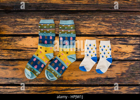 Socken und Babysocken auf rustikalen Holzbank Stockfoto