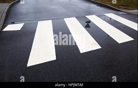 Fußgängerzone Zebrastreifen auf nassem Asphalt Straßenansicht Stockfoto