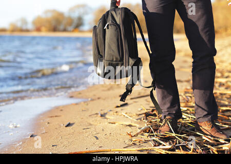 Mann hält in der hand seinen Rucksack am Meer Stockfoto