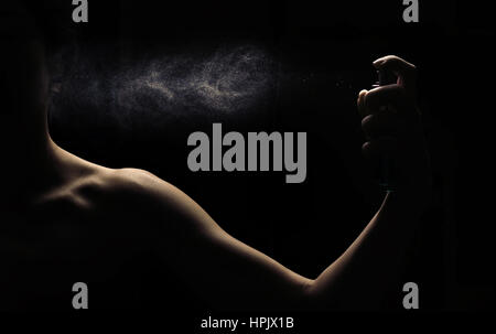 Damen Parfum Spray von Hand auf schwarzem Hintergrund Stockfoto
