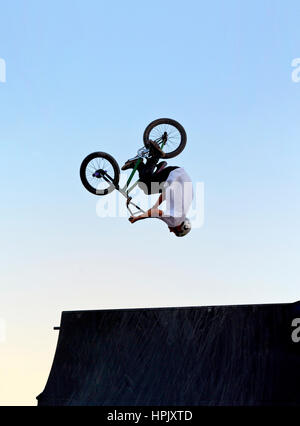 Eine Person, die ein Back flip über eine Fahrrad-Jump-Ramp auf einem BMX-Fahrrad Stockfoto