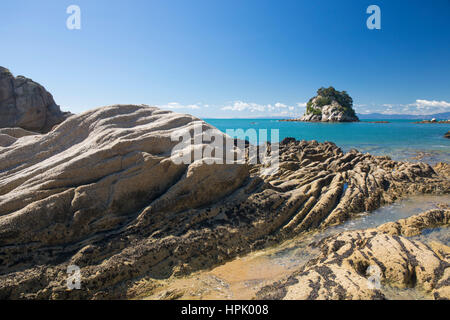 Kaiteriteri, Tasman, Neuseeland. Blick über Tasman Bay vom felsigen Ufer bei wenig Kaiteriteri, Torlesse Rock sichtbar. Stockfoto