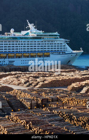 Picton, Marlborough, Neuseeland. Die Royal Caribbean Kreuzfahrt Schiff Voyager of the Seas vor Anker in der Bucht von Shakespeare, riesigen Holzlagerplatz im Vordergrund. Stockfoto