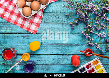 Draufsicht der gefärbten Eiern, Pinsel und Farben für Ostern mit Textfreiraum Stockfoto