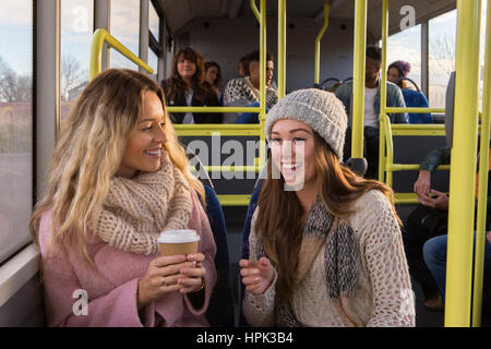 Zwei Frauen reden, als sie zusammen mit dem Bus Reisen. Stockfoto