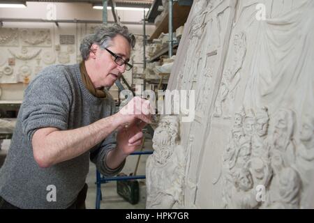 Ottendorf-Okrilla, Deutschland. 22. Februar 2017. Bildhauer Jan Kretzschmar auf eine ovale Reliefs von der historischen Stuckdecke des Frankfurter "Goldene Maßstab" bauen in der Werkstatt von Fuchs und Gierke Bau Und Denkmalpflege GmbH in Ottendorf-Okrilla, Deutschland, 22. Februar 2017 arbeiten. Die Replik von 37 Quadratmeter, hat reich verzierte Stuckdecke aus dem ersten Stock der Frankfurter Fachwerkhauses von Experten aus Sachsen. Das Projekt kostete rund 250.000 Euro. Foto: Sebastian Kahnert/Dpa-Zentralbild/Dpa/Alamy Live News Stockfoto