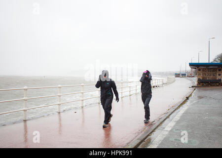 Mann und Frau trotzen Sturm Doris auf der Promenade in Colwyn Bay, North Wales, UK Stockfoto