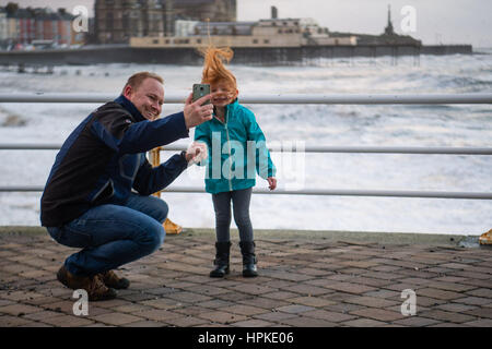 Aberystwyth, Wales, UK. 23. Februar 2017. UK-Wetter: Ein Vater nimmt ein Selbstporträt mit seiner jungen Daighter bei Sonnenuntergang in Aberystwyth nach der Ansturm der Sturm Doris Sturm Doris war die vierte benannt Sturm des Winters, und wurde als eine "Wetter-Bombe" eingestuft (explosive Zyklogenese) von der Met Office Photo Credit: Keith Morris/Alamy Live News Stockfoto