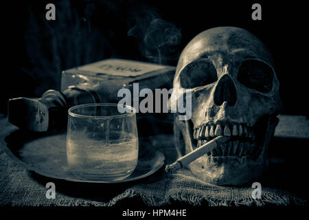 Menschlicher Schädel raucht eine Zigarette auf Still Life-style Stockfoto