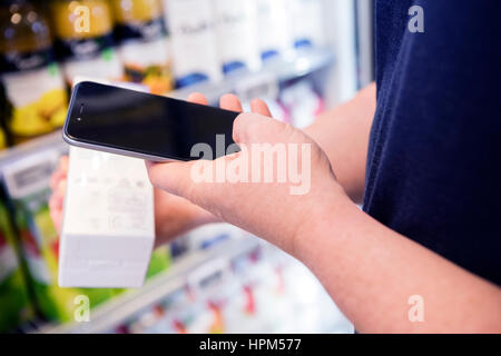 Menschenbild des Produkts Barcode durch Smartphone im Supermarkt Scannen abgeschnitten Stockfoto