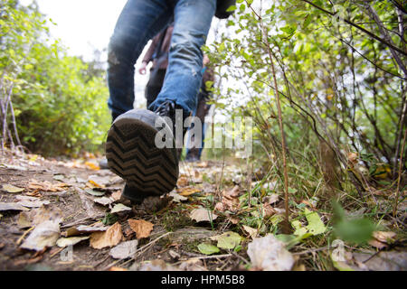 Geringen Teil der Mann Schuhe beim Wandern auf Waldweg Stockfoto