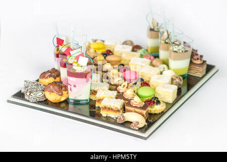 verschiedene Desserts mit Makronen, Kuchen, Pudding, Kekse, Kuchen und Sahne - isoliert auf weißem Hintergrund Stockfoto