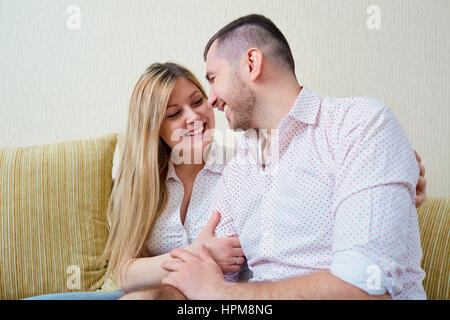 Glücklicher Ehemann und Frau sitzen im Raum. Stockfoto