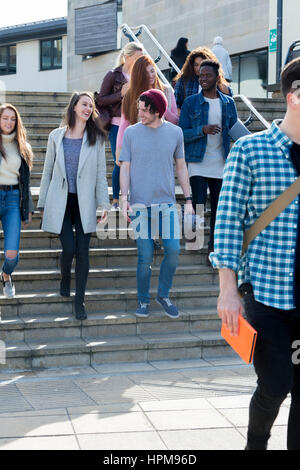 Eine Gruppe von jungen Teenager Studenten Lächeln, als sie durch die Stadt gehen auf eine Pause von der University. Sie tragen ihre Bücher und digitale Tablets. Stockfoto