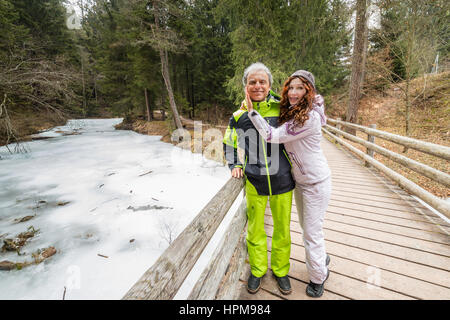 glückliches Ehepaar im Ruhestand im Urlaub umarmt und flirten in der Nähe von gefrorenen Fluss Stockfoto
