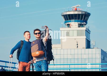 Zwei Freunde, die zusammen reisen. Reisende, die eine Selfie am Flughafen nehmen. Prag, Tschechische Republik. Stockfoto