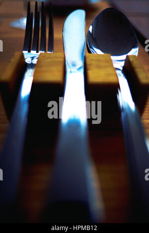 Knofe Gabel und Löffel hautnah in einem hölzernen Halter, Ansicht, dass Punkt blickte die Griffe, die unscharf die Köpfe des Bestecks sind im Mittelpunkt stehen Stockfoto