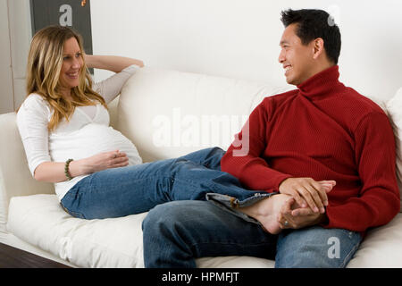 Vater, seine schwangere Frau Füße massieren. Stockfoto