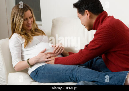 Ehemann Embraceing seine schwangere Frau Bauch. Stockfoto