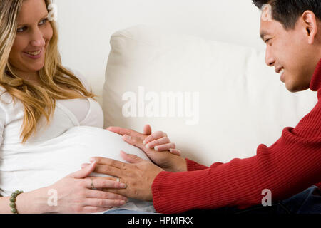 Ehemann Embraceing seine schwangere Frau Bauch. Stockfoto