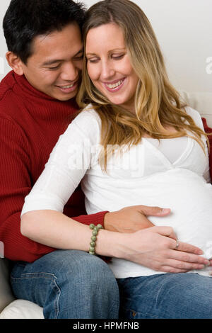 Ehemann Embraceing seine schwangere Frau Bauch. Stockfoto
