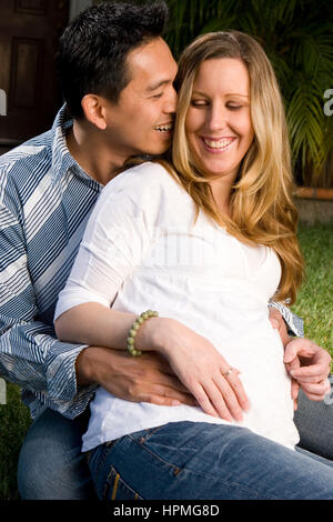 Ehemann Embraceing seine schwangere Frau Bauch. Stockfoto