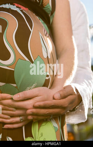 Ehemann Embraceing seine schwangere Frau Bauch. Stockfoto